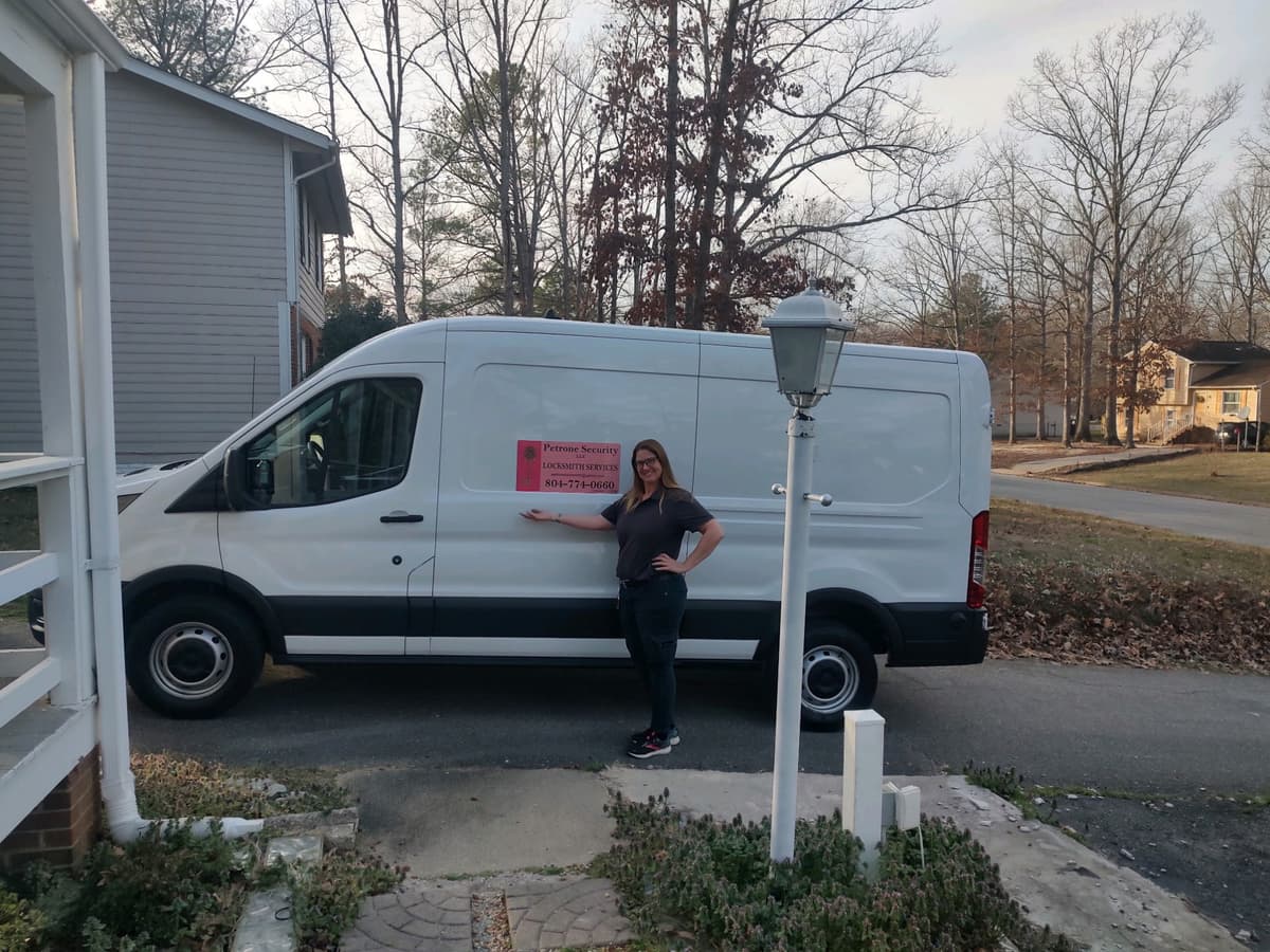 Mary Petrone, professional locksmith, standing beside branded Petrone Locksmith service vehicle